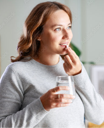 Woman smiling while taking digestive enzyme supplements for better digestive health